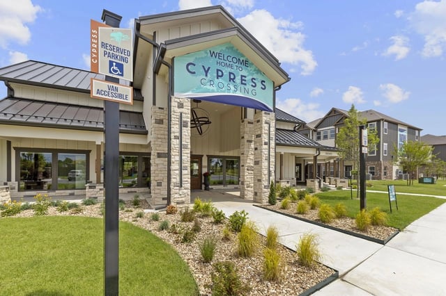 Exterior view of Cypress Crossing community entrance with a covered portico and landscaped walkways.
