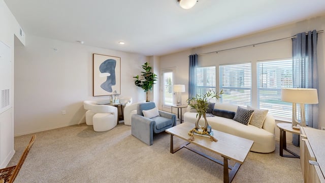 Modern living room with a sectional sofa, armchair, coffee table, and abstract art.