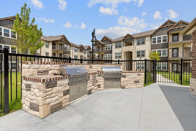 Outdoor grilling station with two built-in grills and stone counter tops.