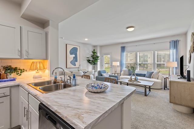 Open concept living area with kitchen island, living room furniture, and dining area.