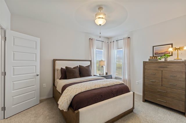 Bedroom with queen bed, nightstand, and dresser.