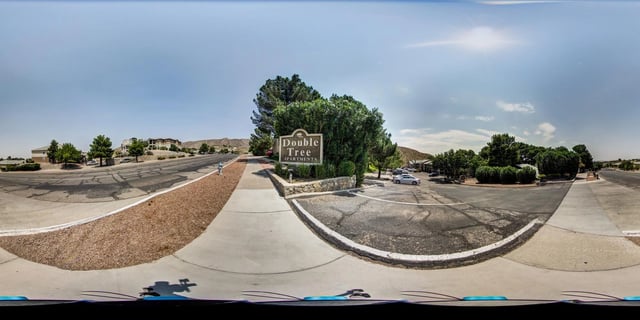 Double Tree Apartments monument sign and entrance to the property with surrounding trees and buildings.