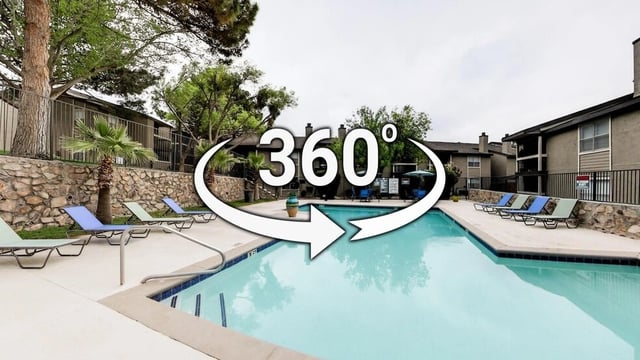 360 view of a swimming pool with lounge chairs and apartment buildings in the background.
