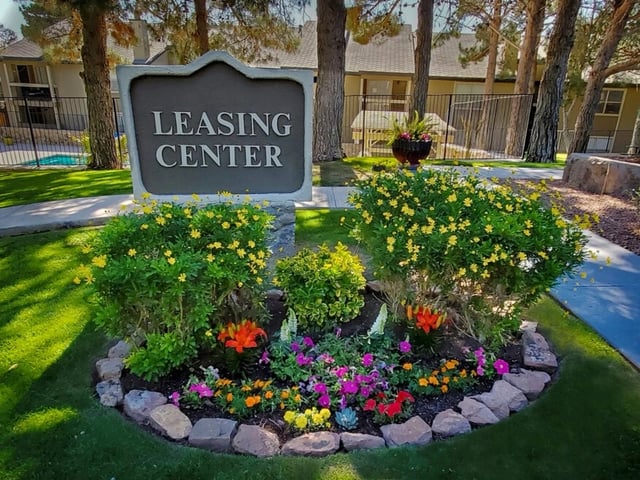 Leasing center monument sign with vibrant flower beds and lush landscaping.