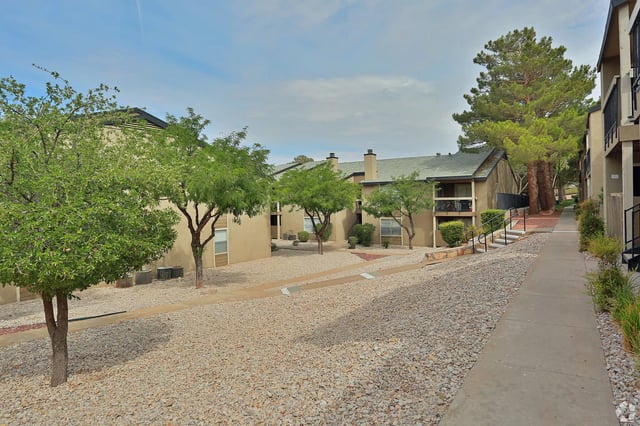 Exterior view of apartment buildings with landscaping and pathways.