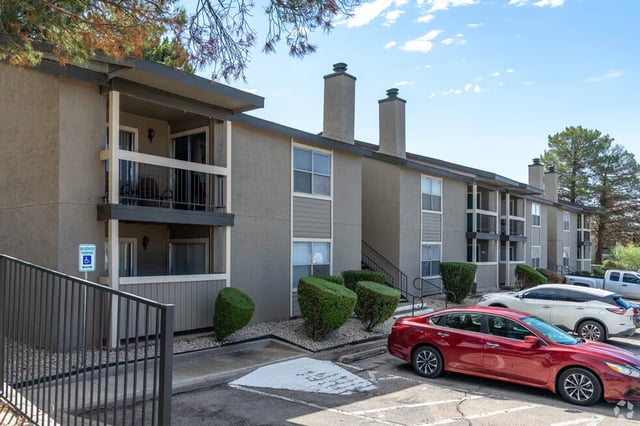 Exterior view of the apartment building with balconies and parking lot.