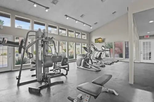 Laundry room with multiple washers, dryers, and a folding table.