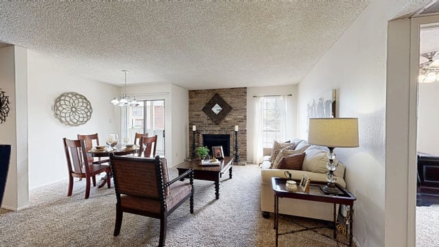 Living room and dining area with fireplace and decorative wall art.