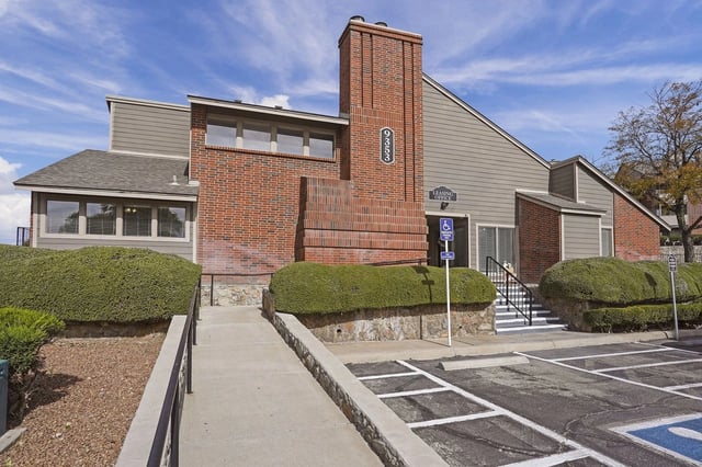 Building exterior with leasing office entrance and parking.