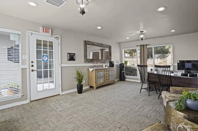 Reception desk and lounge area with coffee station and exit door.