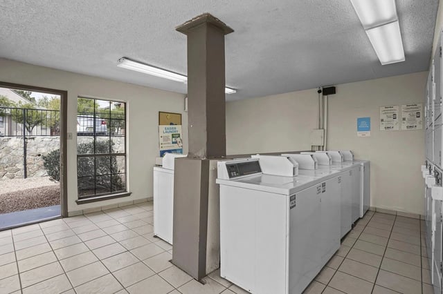 Laundry room with multiple washing machines and dryers.