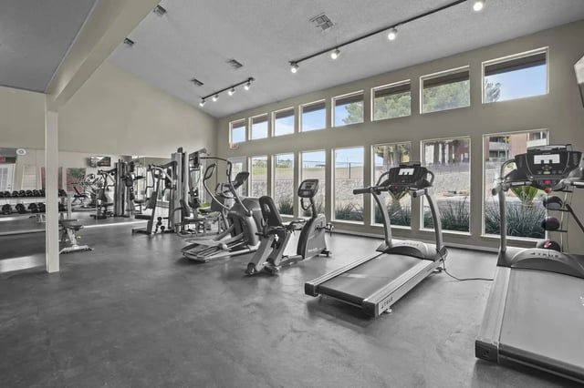 Fitness center with treadmills, ellipticals, stationary bikes, and weight machines.