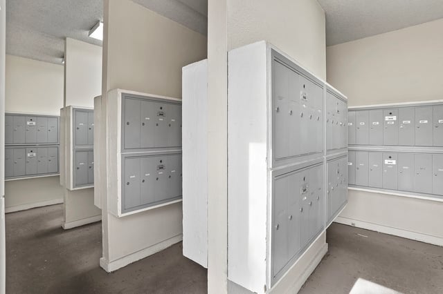Mailroom with multiple banks of gray mailboxes