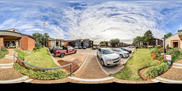 Apartment buildings with parking lot and an American flag.