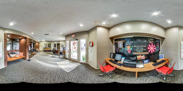 The leasing office reception desk with computers, printer, and colorful artwork.