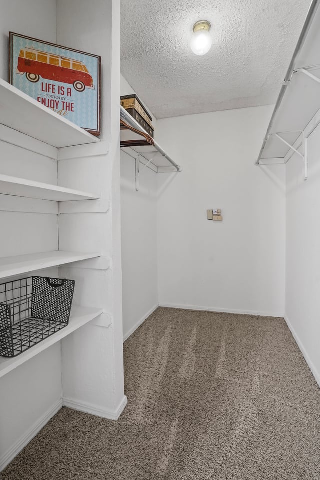 Empty walk-in closet with shelves and hanging rods.