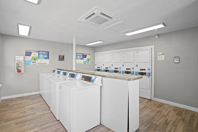 Laundry room with multiple washers and dryers.