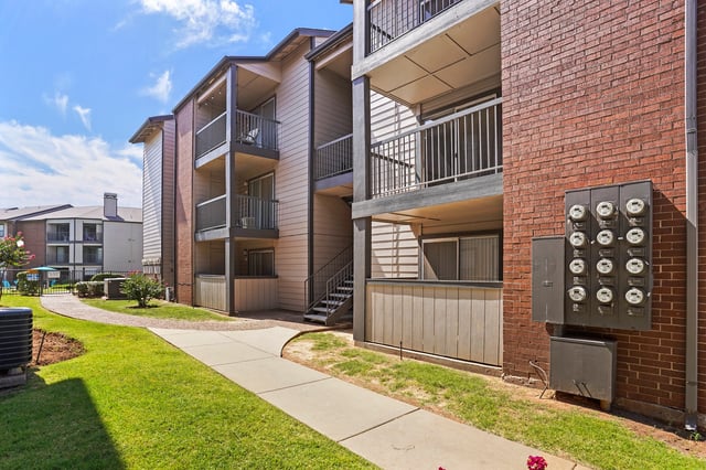 Exterior of apartment buildings with balconies and a walkway.