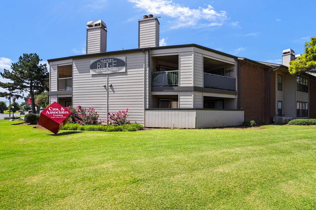 Hunter's Ridge apartment building exterior with a red cube sign in front.