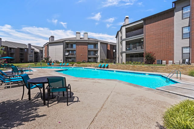 Resort-style swimming pool with lounge chairs and outdoor seating area.
