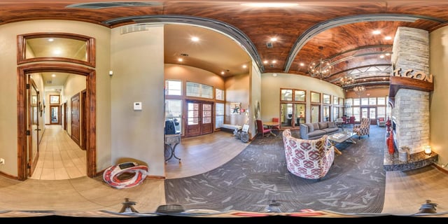 Spacious community lounge with fireplace, seating areas, and decorative elements.