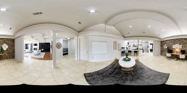 Panoramic view of a spacious apartment living area with a modern kitchen and workspace.