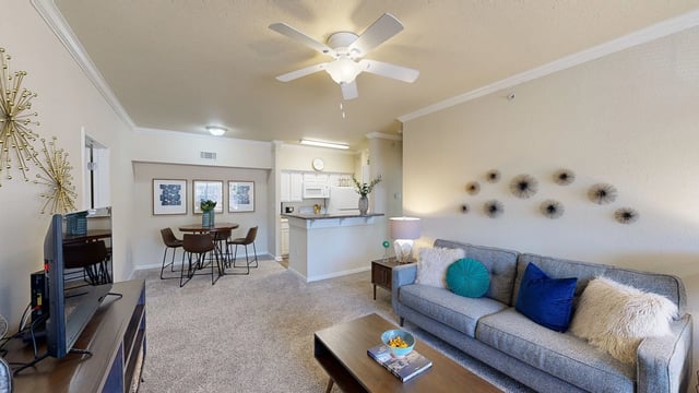 Living room and kitchen area with a sofa, coffee table, dining table, and bar.