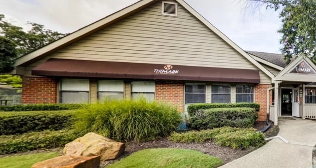 The Mark of Middleland building exterior with brick and siding, awnings, and landscaping.