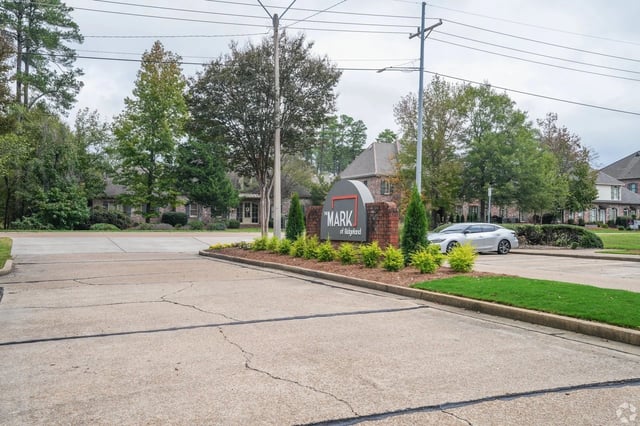Entrance sign for The Mark of Ridgeland apartment community with landscaping and a car nearby