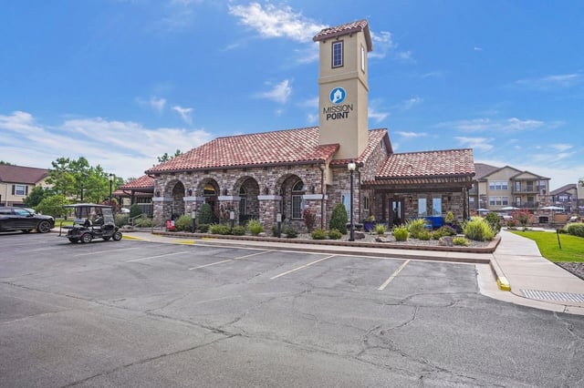 Exterior view of Mission Point community entrance with stone arches and a tall sign.