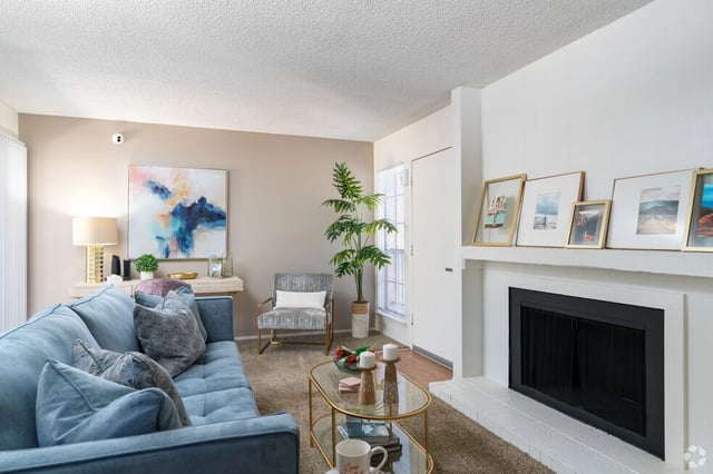 Living room with blue couch, fireplace, and decorative items.