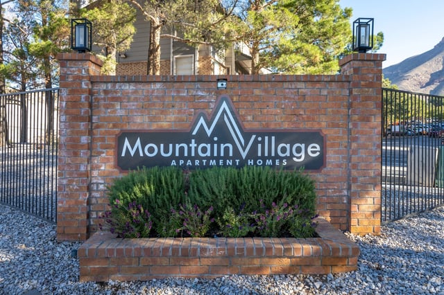 Mountain Village Apartment Homes monument sign with brick pillars and landscaping.