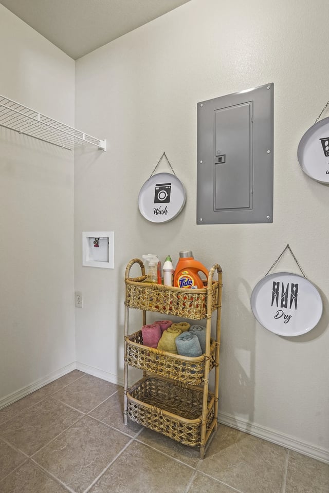 Laundry closet with wicker shelves, towels, detergent, and wall signs reading Wash and Dry.