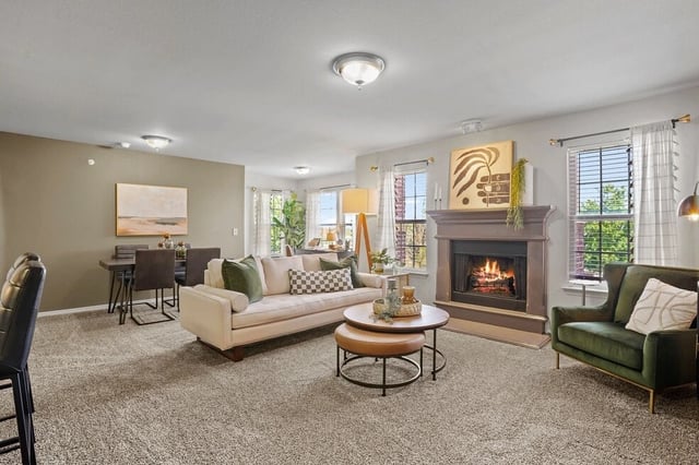Living room with a fireplace, sofa, and dining area.