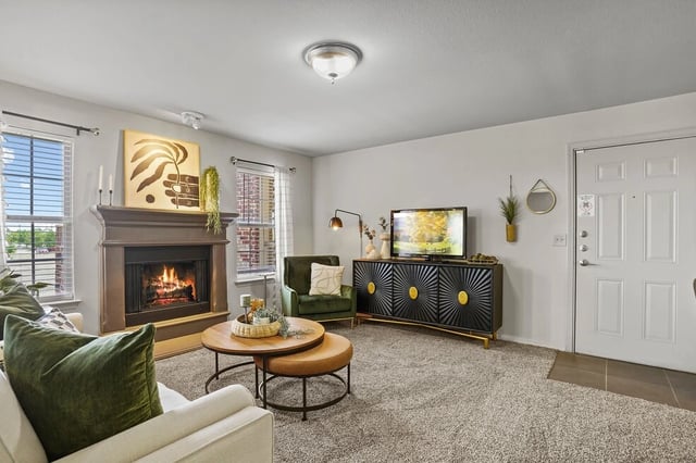 Living room with a fireplace, TV, and two coffee tables.