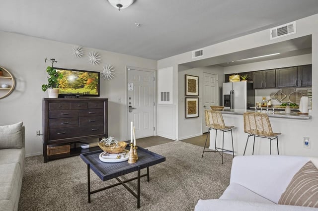 Living room with TV and kitchen counter with bar stools
