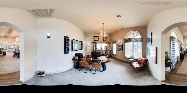 Office space with desks, chairs, and a leather armchair.