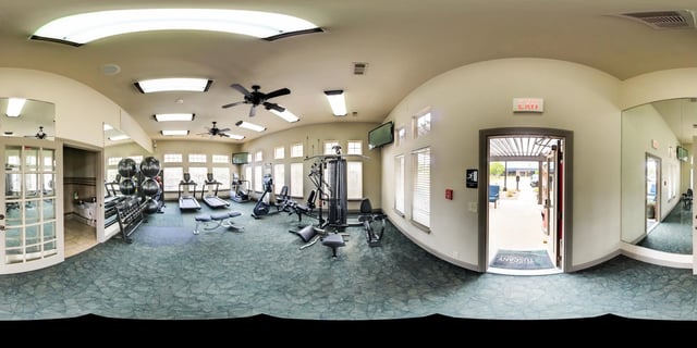 Gym with treadmills, weight machines, free weights, and exercise balls.