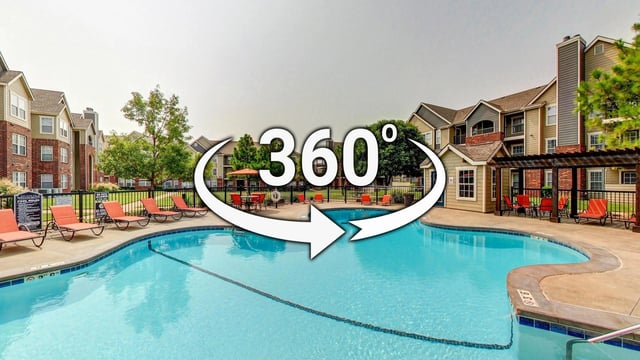 Resort-style swimming pool with lounge chairs and apartment buildings in the background.