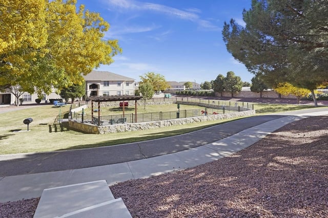 Apartment complex with a fenced dog park and picnic area.