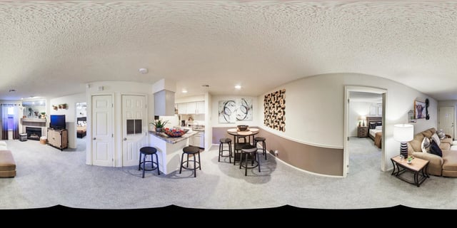 Living room, dining area, kitchen, and bedroom of an apartment.