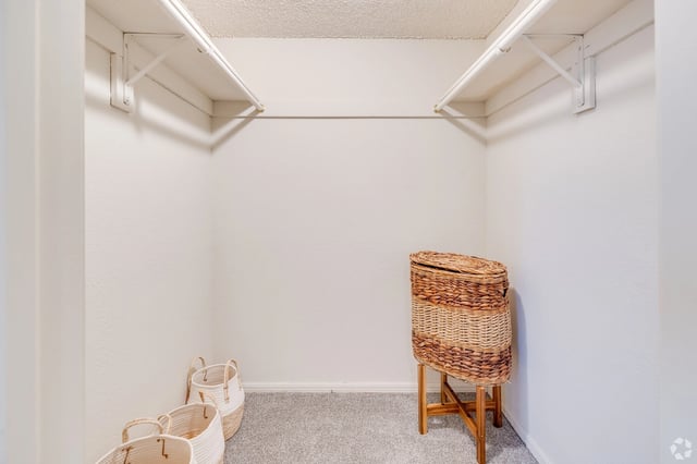 Empty closet with shelving and decorative baskets.