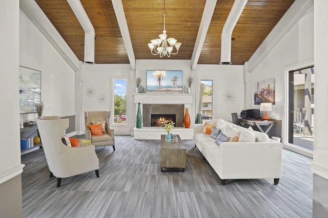 Bright living room with fireplace, white sofa, and large windows.