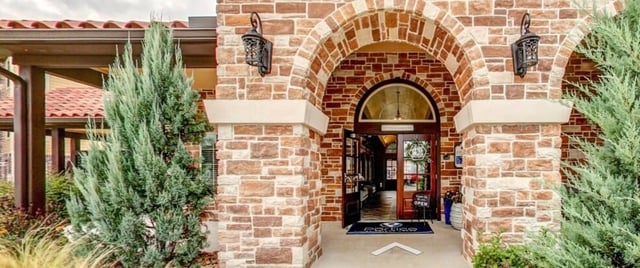 Entrance to the community clubhouse with arched stonework and double doors.