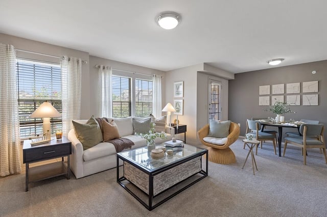 Living room with sofa, coffee table, chair, and dining area.
