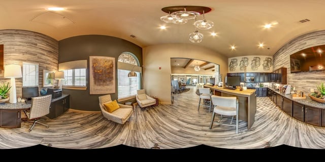 Reception desk and lounge area with seating and a kitchen.