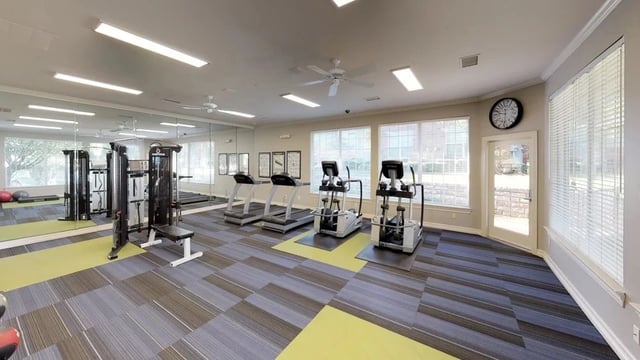 Fitness center with treadmills, elliptical machines, and weight machines.