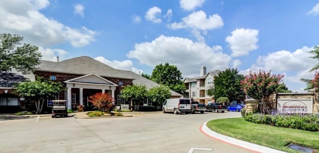 Entrance to Prairie Springs apartment complex with building and monument sign.
