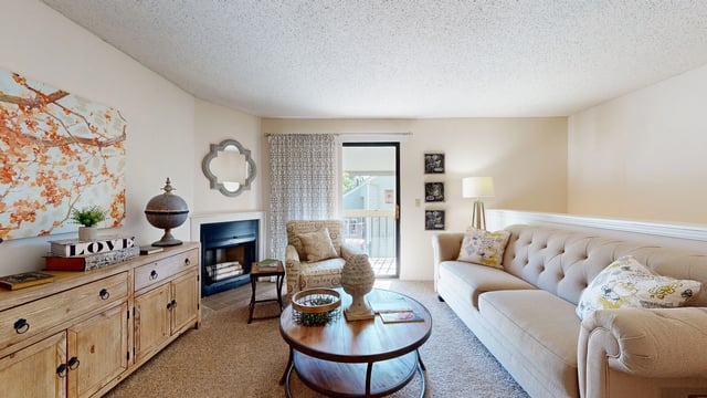 Cozy living room with a fireplace, sofa, and coffee table.