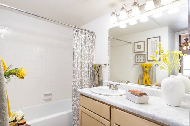 Bathroom with a bathtub, vanity, and mirror.